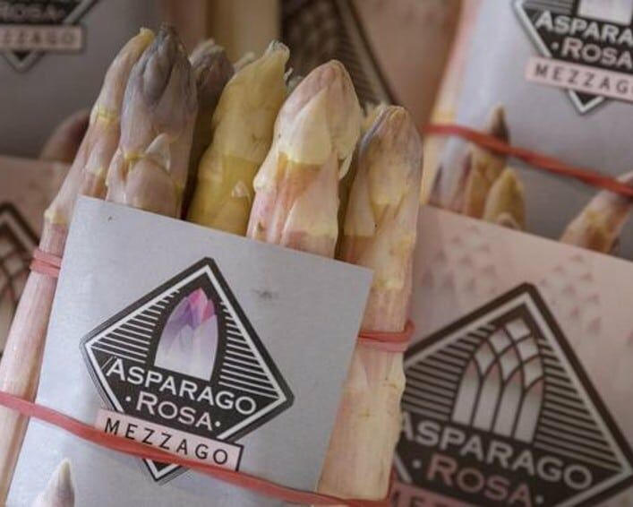 Fumagalli Danilo Ingrosso Ortofrutta Mazzetti di asparagi bianchi e viola sono avvolti in fascette di carta con l'etichetta