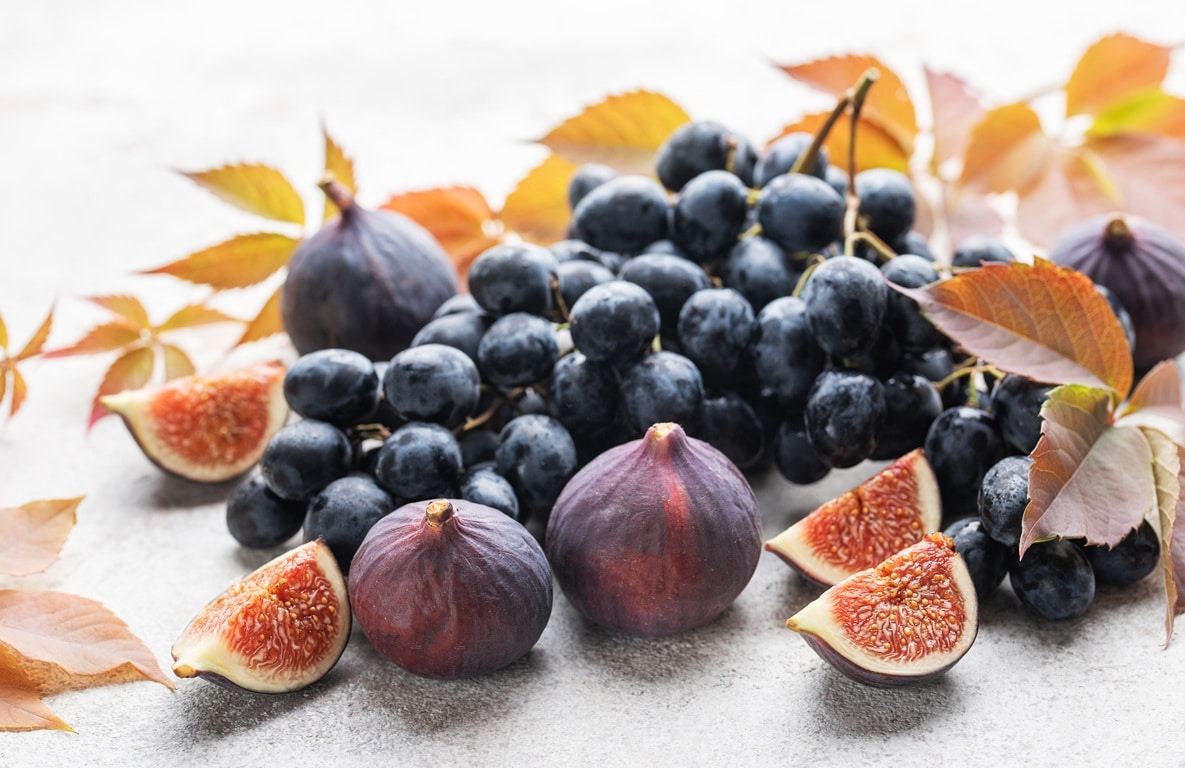 Fumagalli Danilo Ingrosso Ortofrutta Un grappolo d’uva nera e diversi fichi, interi e affettati, sono disposti su una superficie chiara, con foglie autunnali sparse tutt’intorno, evocando la freschezza che contraddistingue Fumagalli Danilo Besana in Brianza, un grossista ortofrutta di fiducia per il settore della ristorazione. Ristorazione Professionale - GDO - retail - privati